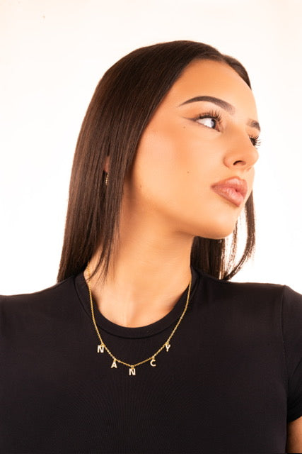 Gros plan collier prénom avec strass brillants - finition or