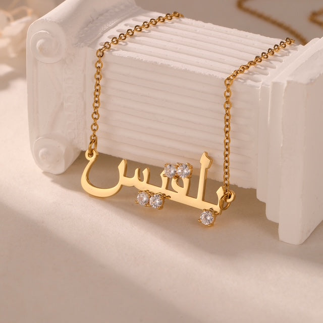 Gros plan gravure prénom arabe collier avec pierre colorée